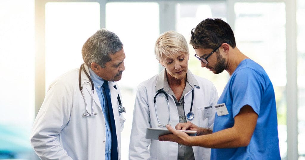 Smart doctors use smart apps. Shot of a team of doctors using a digital tablet together in a hospital.